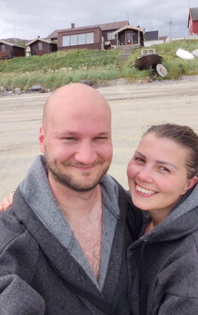 Selfie iloisista uimareista, joiden taustalla Jäämeren sauna