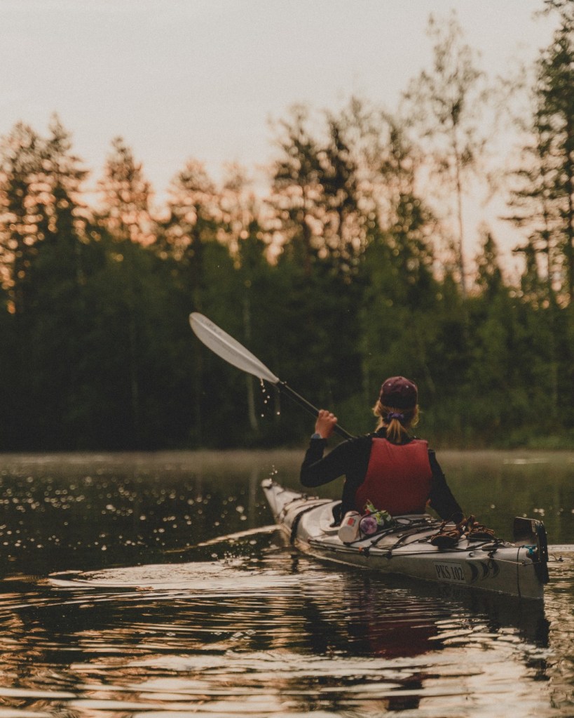 Vehvaa järvellä melomassa aamuyöllä auringonnousun aikaan
