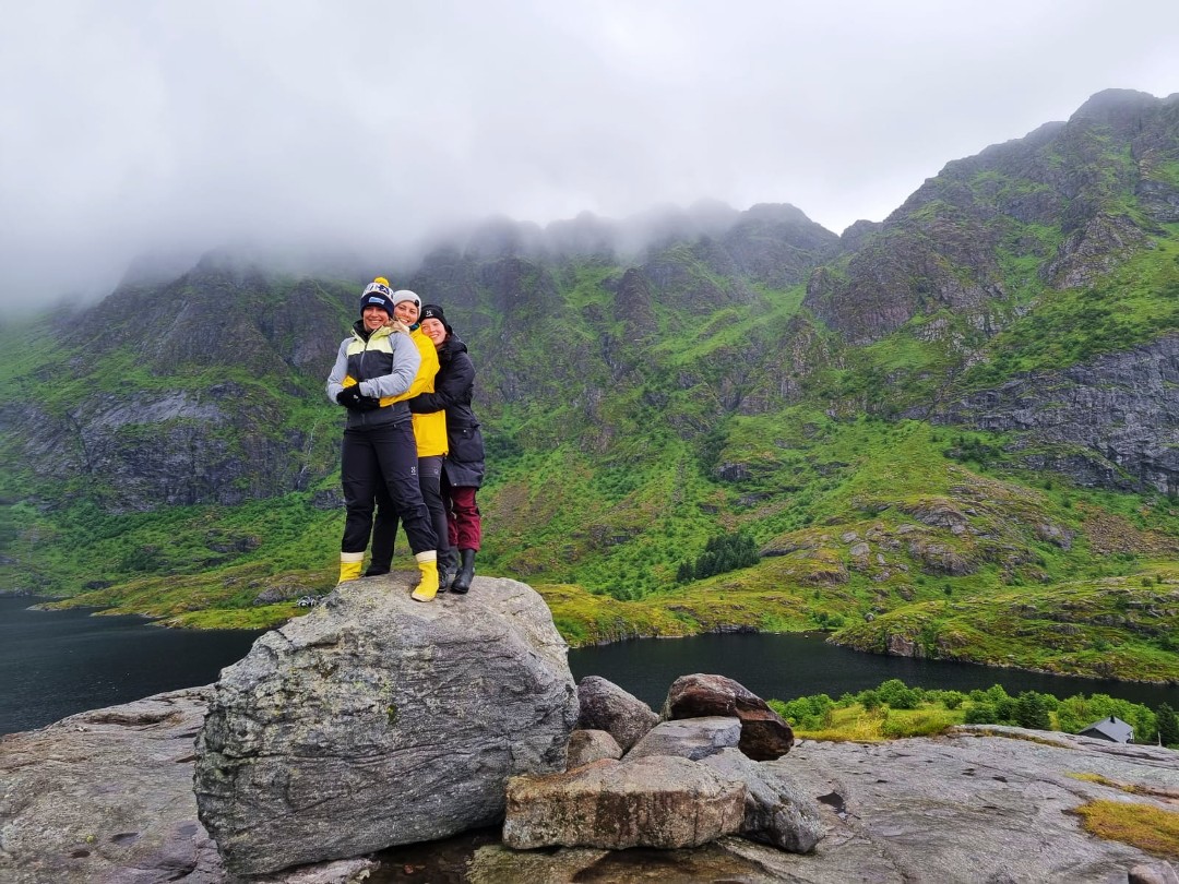 Tyttöporukka kivellä vuorten keskellä