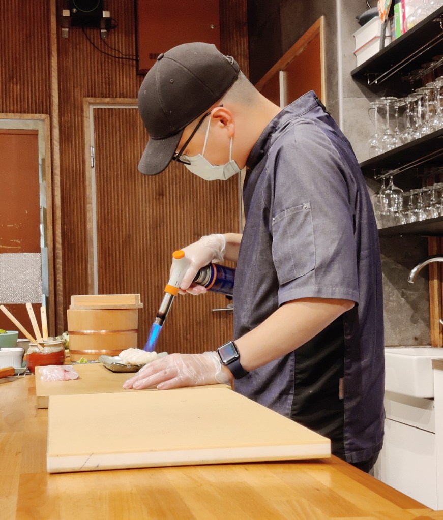 Latitude 25 kokki liekittämässä susheja kaasupolttimella