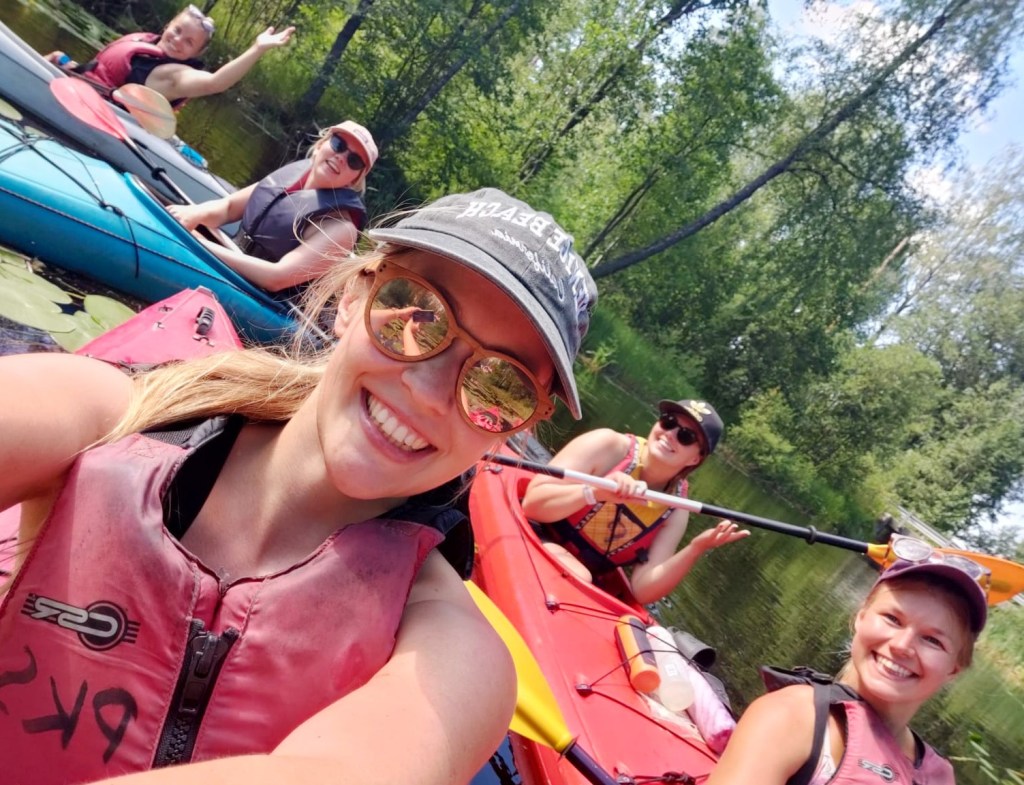 Iloinen seurueselfie kajakkien kera