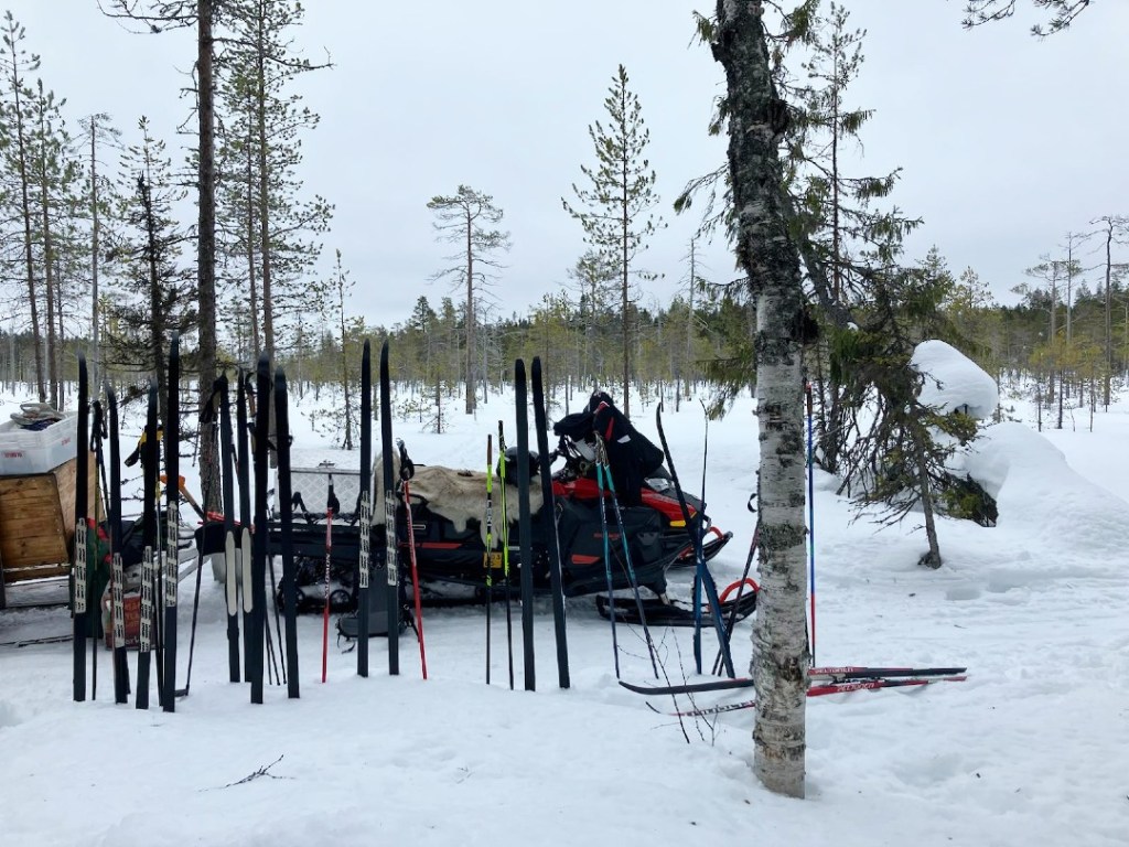 Taukopaikalla sukset ja moottorikelkka